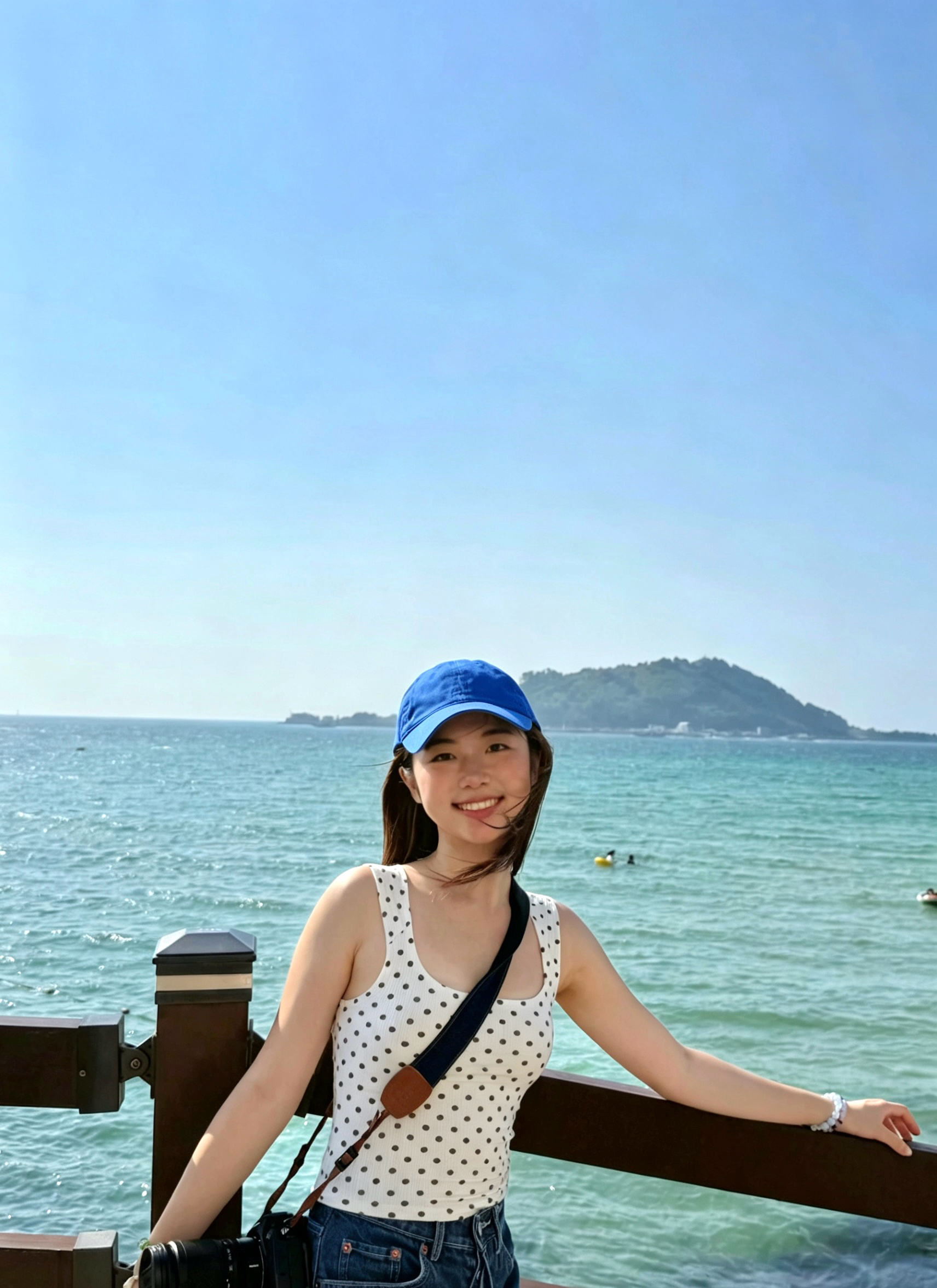 Rita Huang by the sea, holding a camera