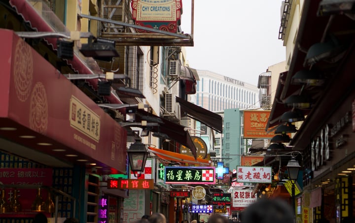 Shop signs and awnings crowding a busy narrow street